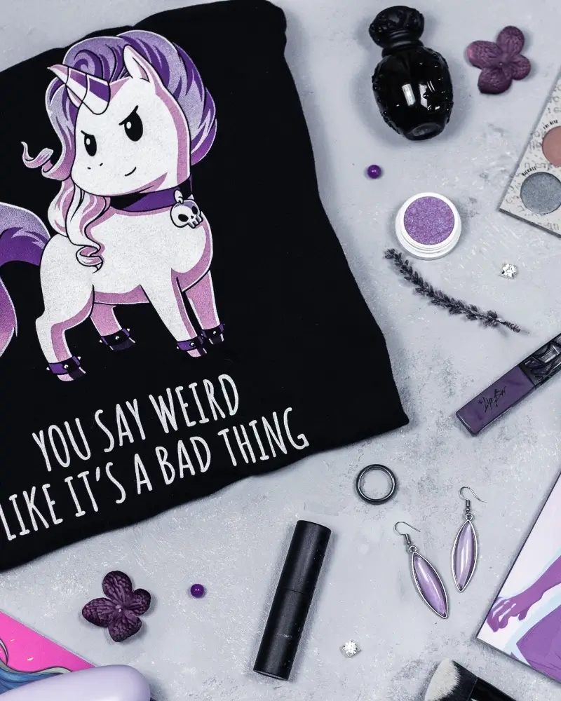 A flatlay with a weird tshirt and beauty accessories to be your own kind of Barbie