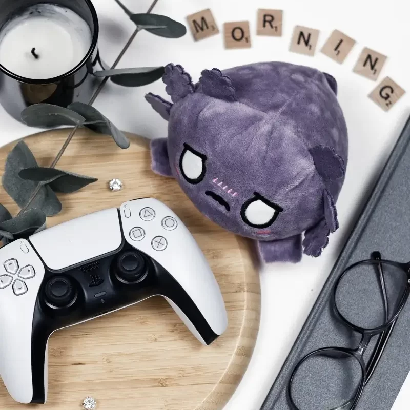 items for a geeky weekend morning routine: controller, plushie candle, journal, glasses