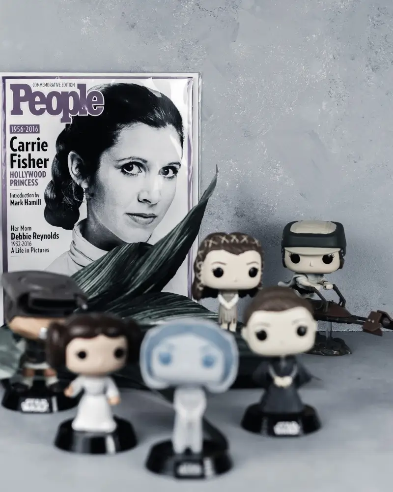 Carrie Fisher on a People Magazine cover surrounded by Funko POPs of Leia Organa from Star Wars